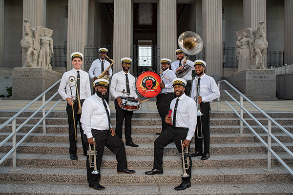 Red And Black Brass Band with instruments outdoors on stairs.
