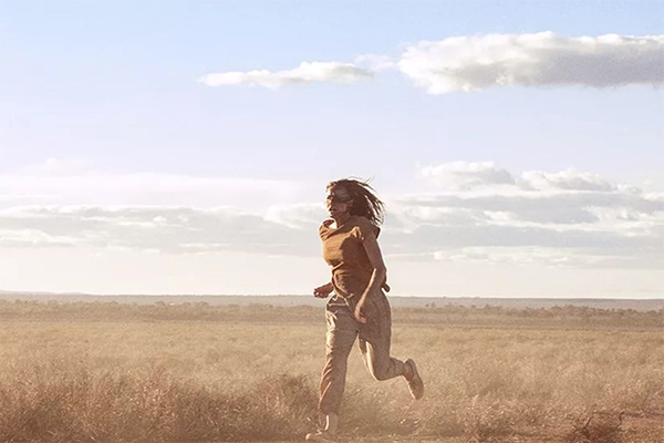 Woman running across a field.