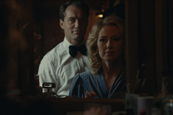 Jude Law and Carrie Coon stare back at themselves in a mirror.